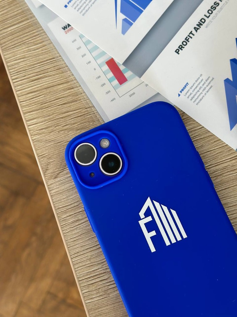 Смартфон FinGlobal на столе рядом с отчётом о прибылях и убытках
